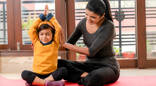 A mother and child exercising together on a yoga mat
