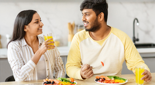 A couple sharing a meal of salad and fresh juice